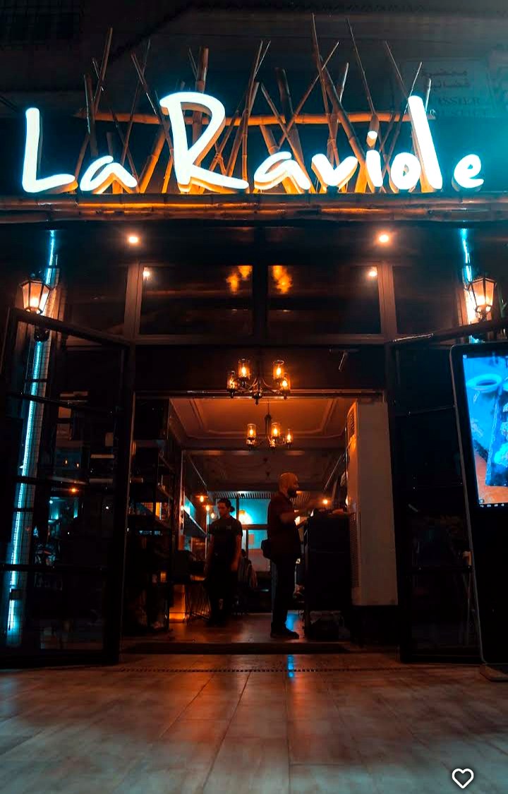 Façade illuminée du restaurant La Raviole à Draria, la nuit